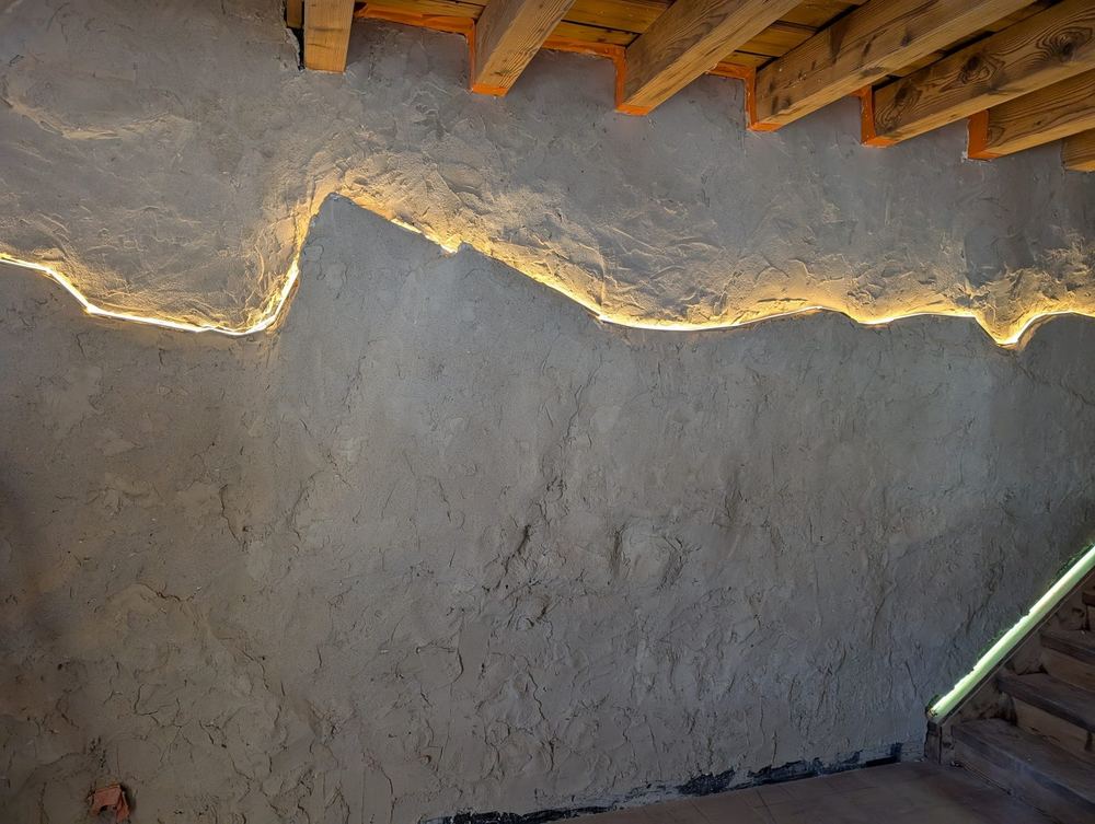 Éclairage LED intégré dans un mur enduit, silhouette de montagne